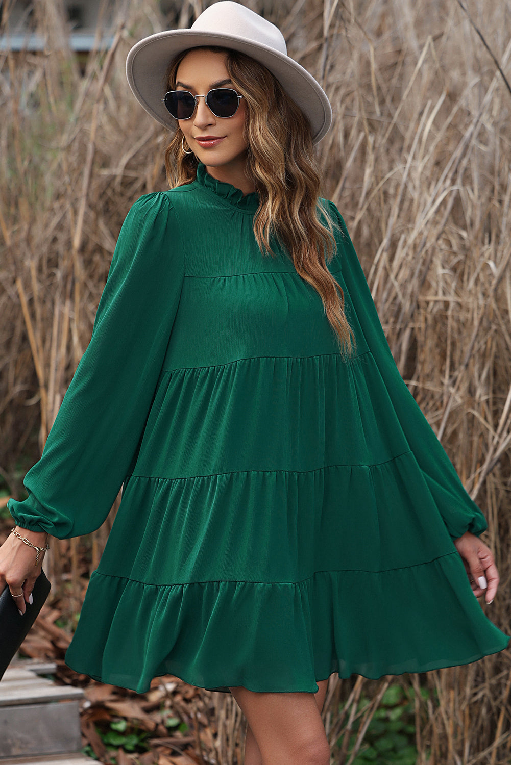 Green dress with ruffles and puffed sleeves, high neck, bow in the back