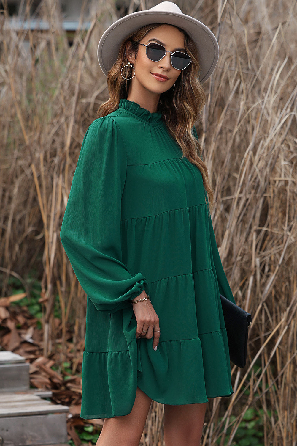 Green dress with ruffles and puffed sleeves, high neck, bow in the back