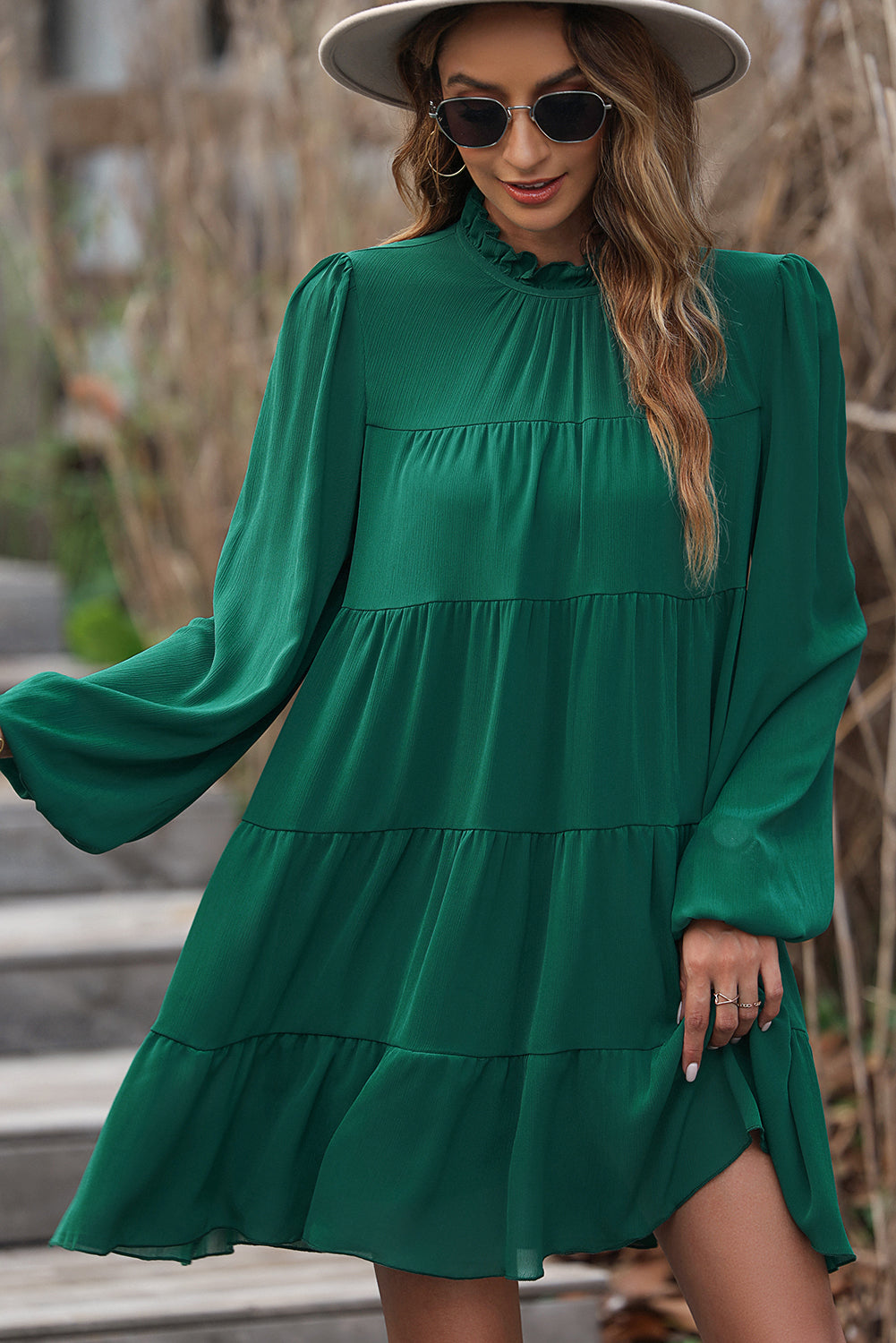 Green dress with ruffles and puffed sleeves, high neck, bow in the back