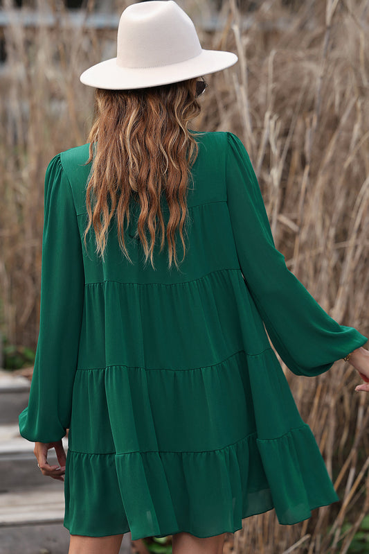 Green dress with ruffles and puffed sleeves, high neck, bow in the back