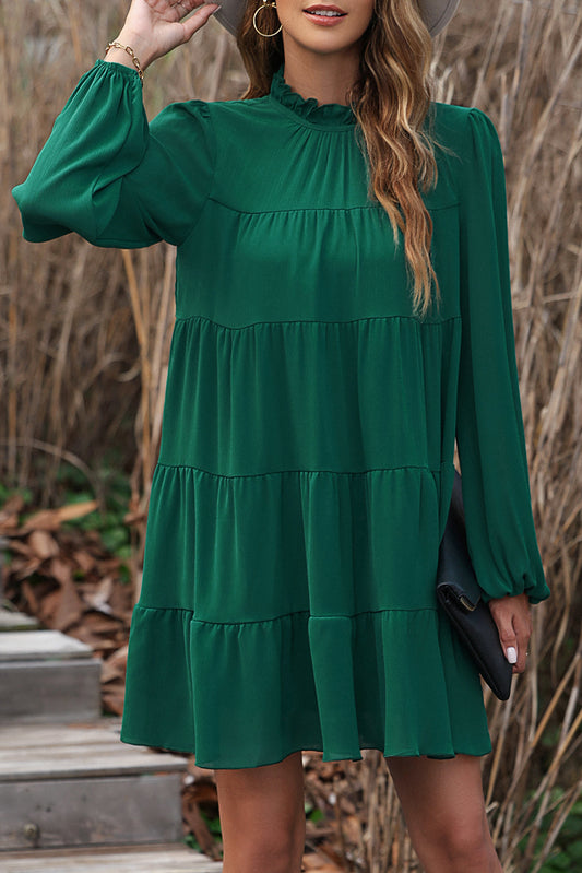 Green dress with ruffles and puffed sleeves, high neck, bow in the back